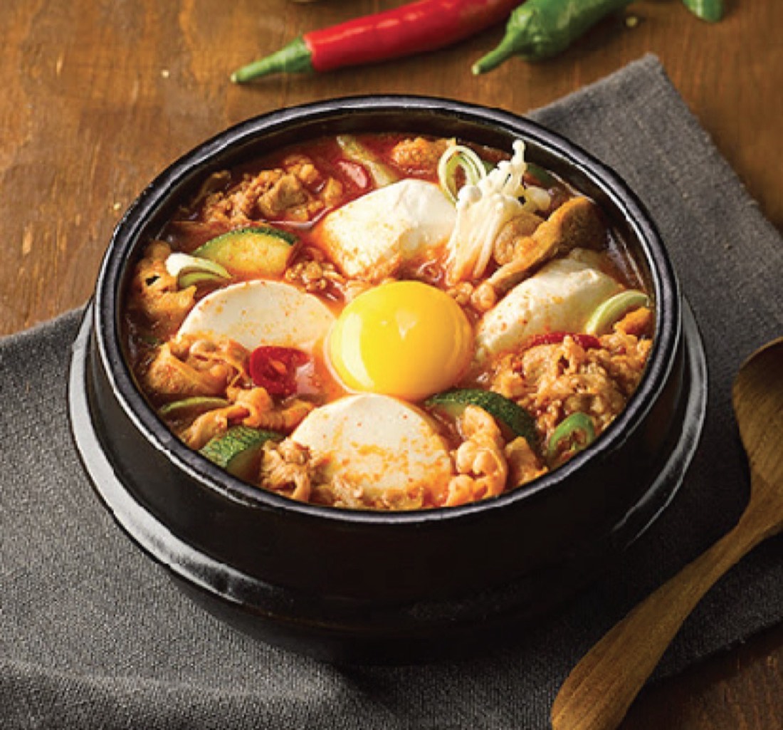 Spicy extra soft tofu soup with egg in a stone bowl