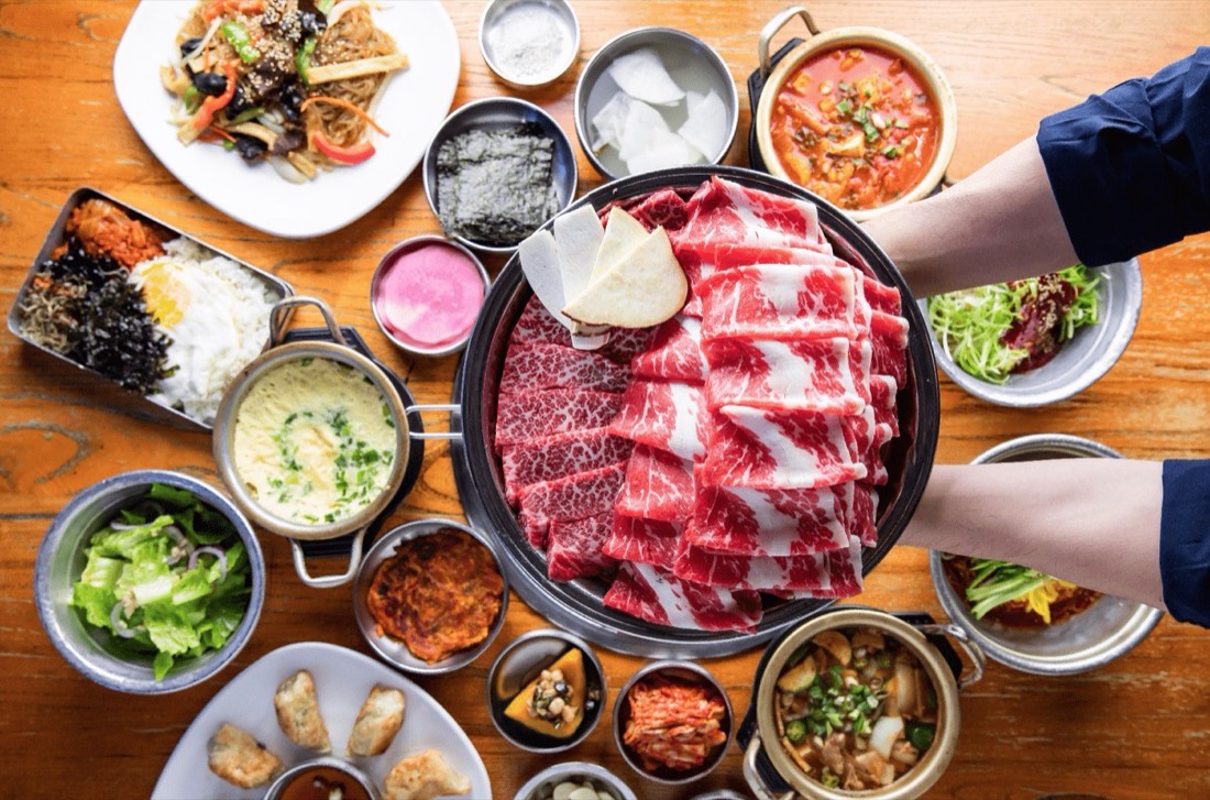 Korean BBQ spread with marbled beef platter and banchan